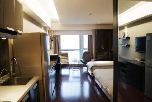 南京Kaibin Apartment- Nanjing University Branch的客房设有一张床和一个带水槽的厨房