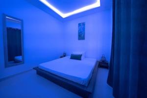 达喀尔Le charmant的蓝色客房中一间带床的卧室