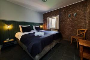 费伦Het mooiste uitzicht-De Oogappel的一间卧室设有一张大床和砖墙