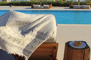 米克诺斯城Adama Mykonos Boutique Hotel的一张桌子,上面有毯子,在游泳池边