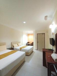 珍南海滩Kenangan Inn的酒店客房设有两张床和电视。
