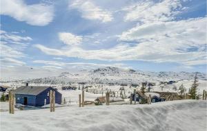 弗洛Beautiful Home In Fl With Sauna的山地的一片雪覆盖着蓝色的房子