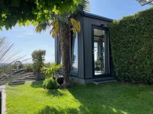 帕绍Tinyhouse mit Alpen- Stadt- und Poolblick , WLAN的院子里有棕榈树的黑房子