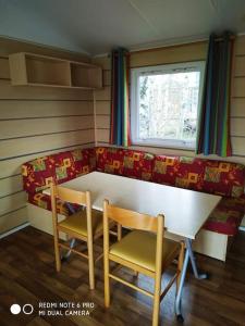 NagesMobil home au bord du lac的配有桌子、两把椅子和一张沙发的房间