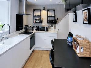 Bardon MillThe Nook的厨房配有白色橱柜和黑色桌子