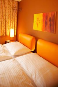 萨尔茨堡珀斯特绿色酒店 - 100％比奥的一间卧室设有两张床,墙上挂着一幅画