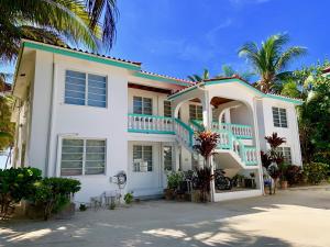 圣佩德罗Coral Bay Villas的白色的房子,有蓝色的楼梯和棕榈树