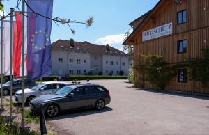 旧明斯特Aktivhotel Wildschütz的两辆汽车停在大楼旁边的停车场