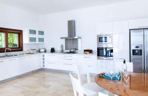 卡斯The Korsan Kuzey的厨房配有木桌和白色橱柜。