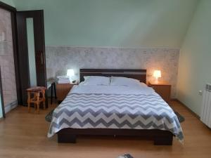 普雷代亚尔可可旅馆的卧室内的一张大床,配有两张桌子和两盏灯