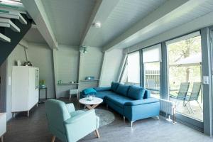 RonshausenFerienhaus Waldperle的客厅配有蓝色的沙发和两把椅子
