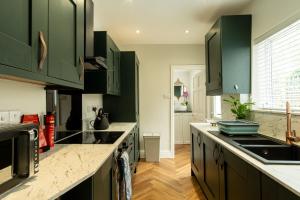 HugglescoteEllistown Retreat的厨房配有绿色橱柜和台面