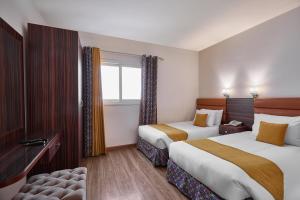 开罗金卡文酒店的酒店客房设有两张床和窗户。