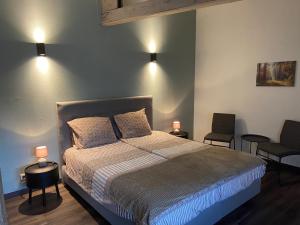 奥多恩De Heide的一间卧室配有一张带两把椅子和两盏灯的床。