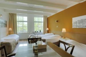 阿姆斯特丹阿姆斯特丹王子酒店的酒店客房设有两张床和一张桌子。