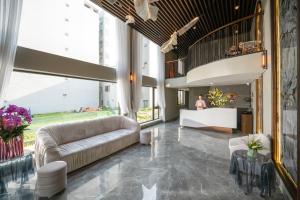 岘港Tashi Ocean Hotel & Apartment Da Nang的大厅,在大楼里配有沙发和桌子