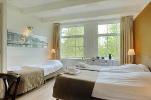 阿姆斯特丹阿姆斯特丹王子酒店的一间卧室设有两张床和窗户。