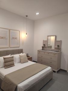 TarxienCasetta Pulis (Close to Airport & Valletta)的一间卧室配有一张床、梳妆台和镜子