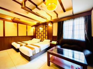 大阪嵐 Hotel Arashi 心斎橋店的酒店客房,设有两张床和一张沙发