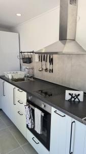 尼尔斯吉尼Greco Paradise Suites - ADULT ONLY的厨房配有水槽和炉灶 顶部烤箱