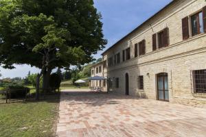 法诺Locanda di Montegiove的旁边是一座大砖砌建筑,旁边是树