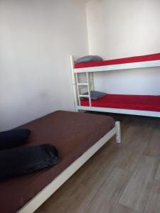 大普拉亚Hostel Mar da Vila的一间卧室设有两张双层床,铺有木地板。