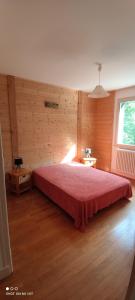BonlieuGîte grande capacité au calme circuit Cascades du Hérisson的卧室配有红色的床,位于木墙内