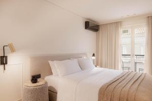 毕达哥利翁Doryssa Theorem Hotel的卧室设有一张白色大床和一扇窗户。