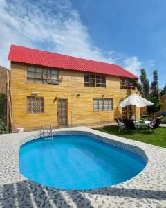 卢那欢纳Casa de Campo Villa Angélica Lunahuaná的一座带游泳池和红色屋顶的房子