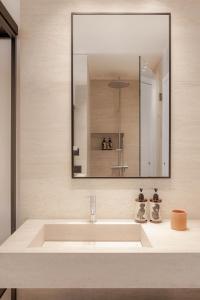 毕达哥利翁Doryssa Theorem Hotel的浴室设有白色水槽和镜子