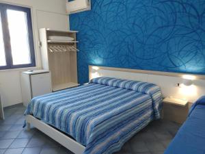 托雷瓦多Bed and breakfast Delfino Blu的一间卧室设有一张床和蓝色的墙壁