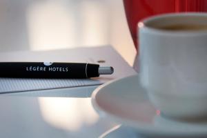 比勒费尔德LÉGÈRE HOTEL Bielefeld的一杯咖啡,旁边是一本书,一杯咖啡