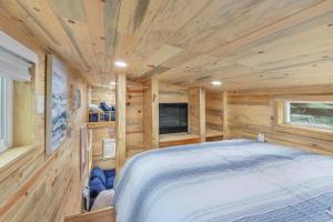 德里平斯普林斯Arbor House of Dripping Springs - Serenity Hollow的小木屋卧室配有1张床和电视