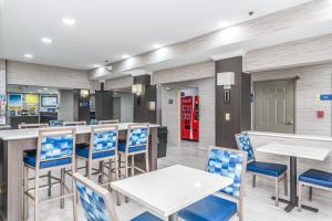 普拉特维尔普拉特维尔戴斯套房酒店的餐厅设有白色的桌子和蓝色的椅子