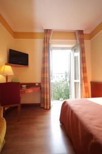 韦尔巴尼亚Il池沃斯特罗酒店的一间卧室配有一张床、一张书桌和一个窗户。