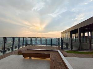 吉隆坡Mikael Homestay Kuala Lumpur的一座带长凳的建筑,阳台享有日落美景