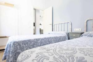 Villarroya de los PinaresApartamento creativo VillaRubei Los Chorros的一间卧室配有两张带蓝白色床单的床