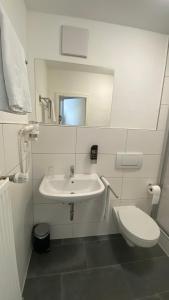 巴特阿巴赫Pension Rathaus的白色的浴室设有水槽和卫生间。