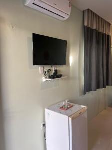 巴雷里尼亚斯Pousada Mangaba的一间设有壁挂式电视和冰箱的客房