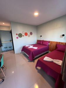 巴雷里尼亚斯Pousada Mangaba的一间卧室配有两张紫色床单