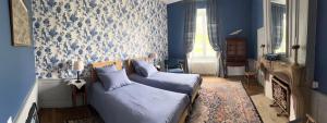 MauvillyChâteau de Mauvilly的一间卧室设有蓝色的墙壁、一张床和一个壁炉