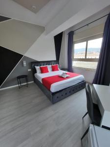 墨西拿U Baruni B&B的一间卧室配有一张带红色枕头的床和一扇窗户