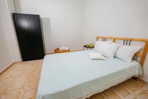 尼亚米卡尼奥纳Seashell Guesthouse的卧室配有白色大床和白色枕头