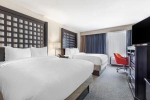 普莱诺Comfort Inn Plano-Dallas的酒店客房设有两张床和电视。
