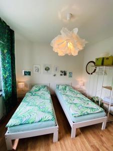 维勒斯威特Eifel-House - FeWo的带吊灯的客房内的两张单人床