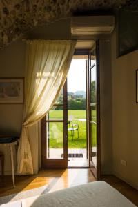 明乔河畔的瓦雷奇奥La Guarnigione的卧室设有通往庭院的门。