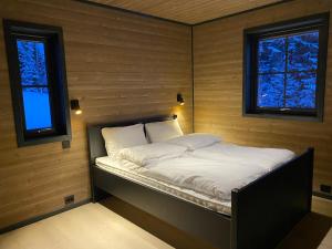 史特林Stryn Mountain Lodge的一张小床,位于带两个窗户的房间