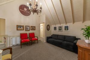 格拉玛多Hotel Monte Felice Bosque的客厅配有沙发和2把红色椅子