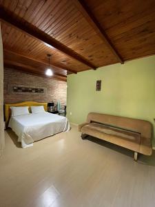 Estancia do CastelloPousada Lua e Sol的一间卧室配有一张床和长凳