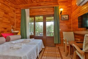 契拉勒Çıralı Orange Motel的一间卧室配有一张床、一张桌子和一个窗户。